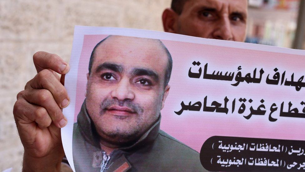 Мужчина держит фотографию Мохаммеда Халаби во время митинга солидарности у офиса Международного комитета Красного Креста в Газе Город (30 августа 2022 г.)
