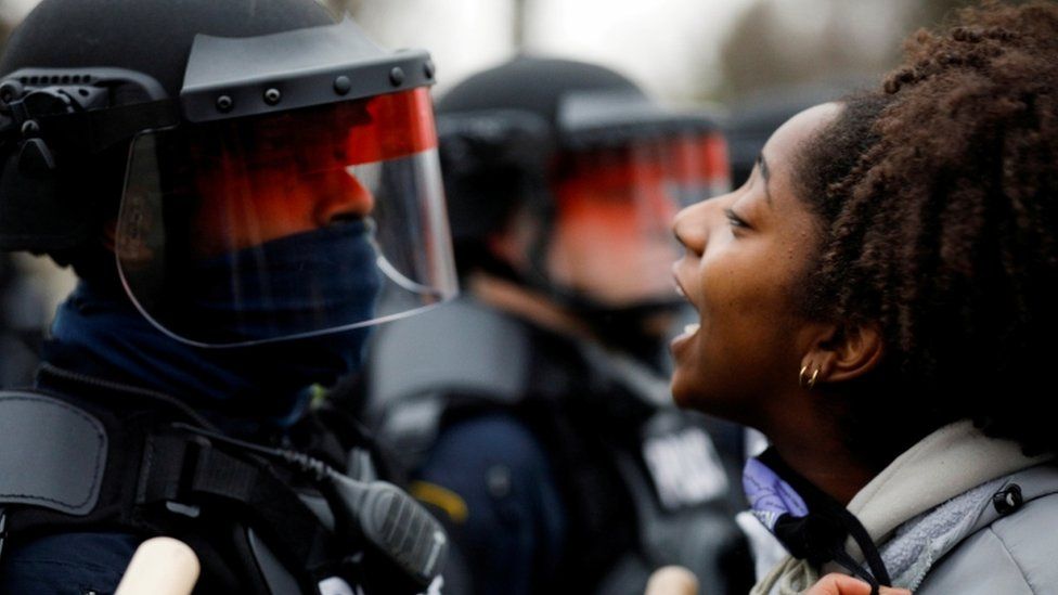 A woman yelling in the face of a police officer