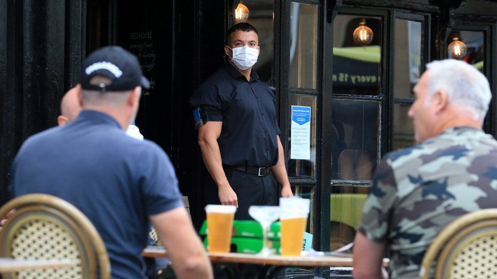A doorman wearing PPE outside a pub in Newcastle