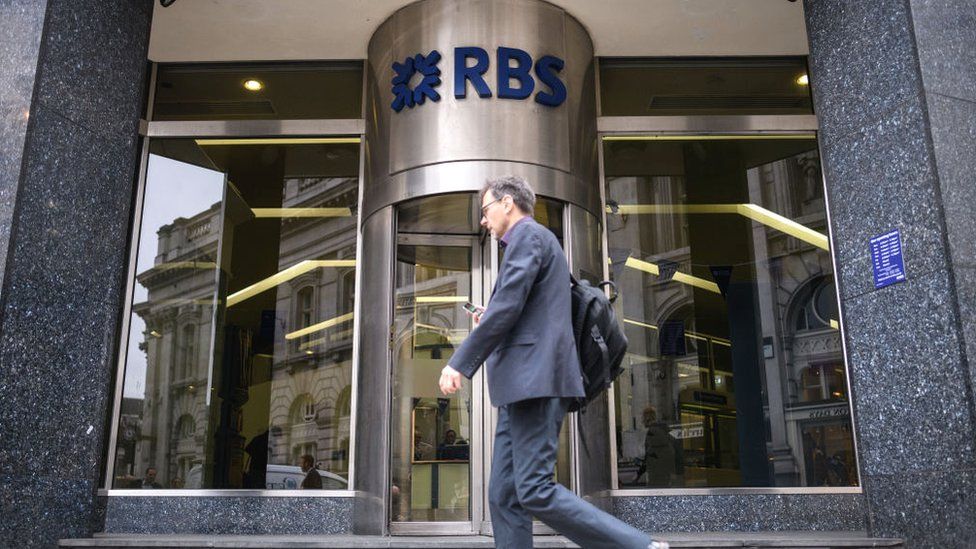 A commuter walks past a branch of RBS bank