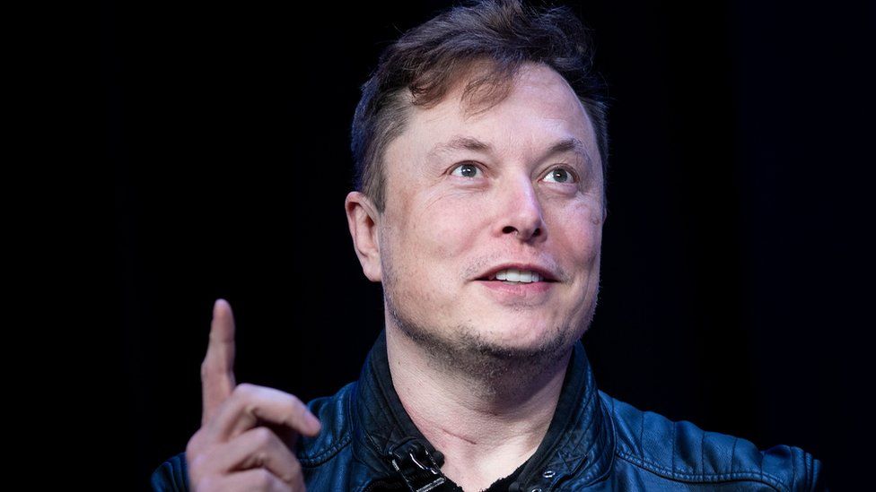 Elon Musk raises a finger while speaking in this file photo from March 2020