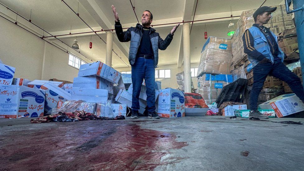 A Palestinian man reacts as blood is seen on the floor at an UNRWA aid distribution centre in Rafah, southern Gaza, following an alleged Israeli air strike. Photo: 13 March 2024