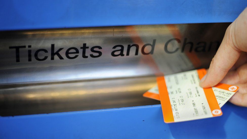Person taking train tickets out of a ticket machine