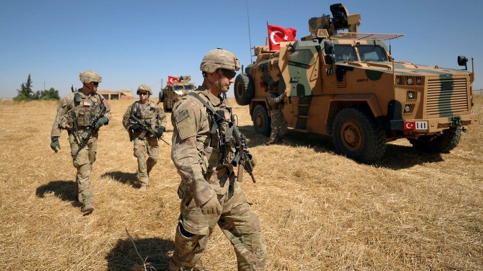 US soldiers walk together during a joint patrol with Turkish forces near Tal Abyad, Syria (8 September 2019)