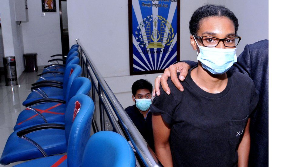 An American woman and self-described digital nomad Kristen Gray looks on after being examined at the Indonesian Immigration office in Denpasar, Bali, Indonesia