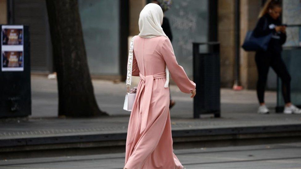 A Muslim woman, wearing the style of dress called an abaya, walks in a street in Nantes, France, August 29, 2023