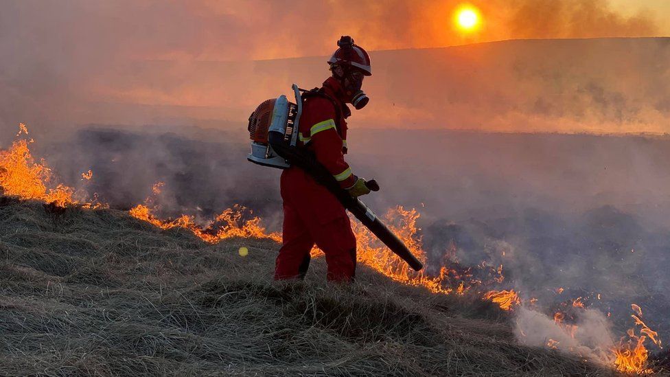 A firefighter uses a blower