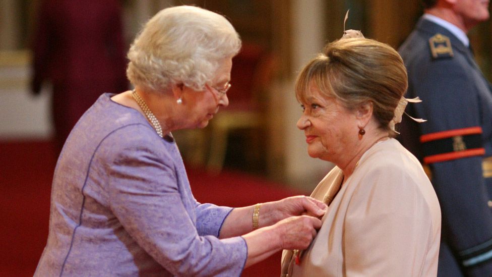 Архивное фото от 18.10.2007, на котором Сильвия Симс получает ВТО от королевы в Букингемском дворце.