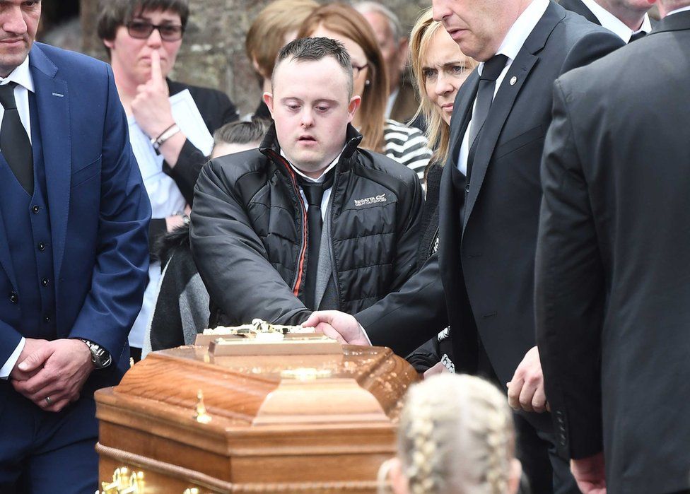 Concepta Leonard's son Conor Gallagher looks at her coffin at her funeral in 2017