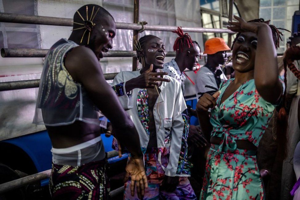 Models dance and sign during a break at the backstage of main show of the Kibera Fashion Week in the informal settlement of Kibera in Nairobi, on October 15, 2023. Kibera Fashion Week is a platform created from the community to redefine fashion and creativity while showcasing beauty and talent as a way to change the narrative about Nairobi's largest informal settlement.