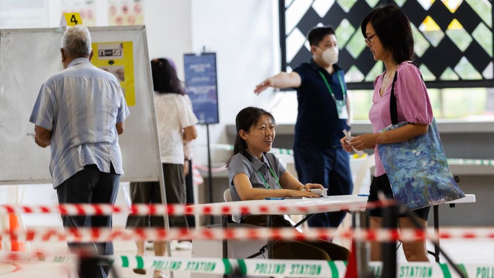 Граждане регистрируются для голосования на избирательном участке на президентских выборах в Сингапуре