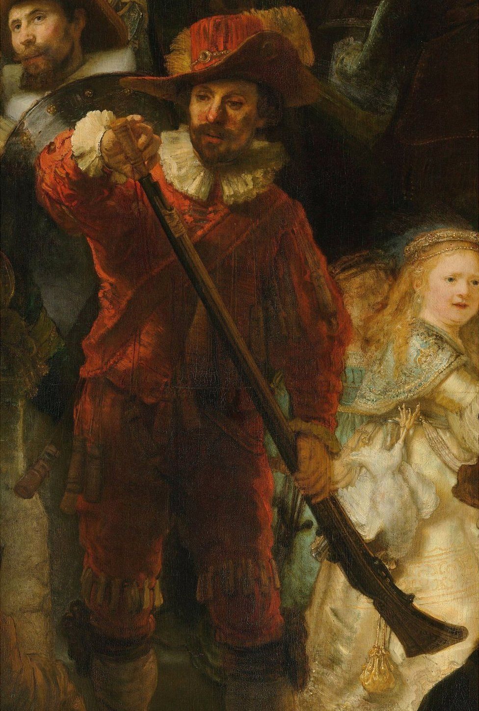 Musketeer dressed in red with white collar and cuffs, is loading his musket with gunpowder, and young girl in gold dress