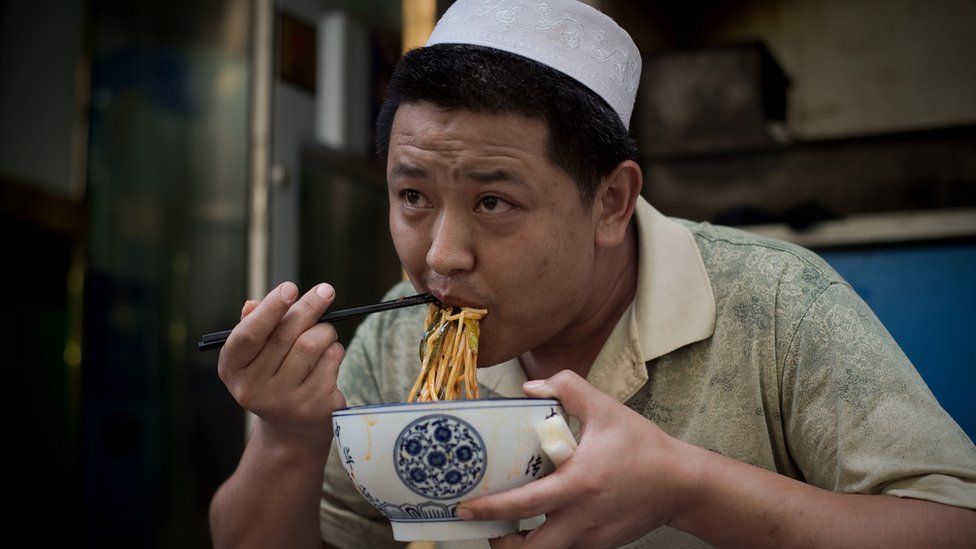 A Chinese Muslim eats noodles outside the Niujie mosque during the Muslim fasting month of Ramadan in Beijing on July 1, 2016.