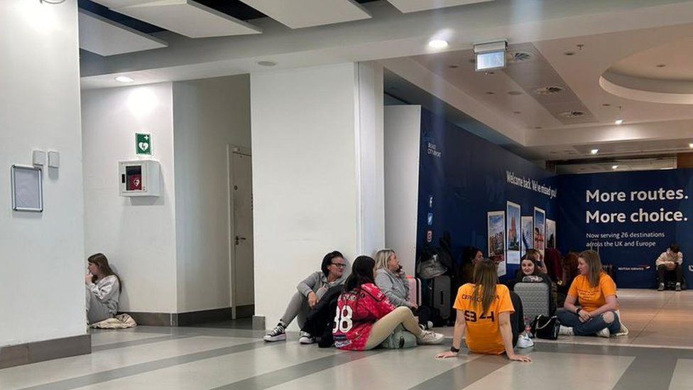 The Steelers fans waited for news of their flights on the floor of Belfast City Airport