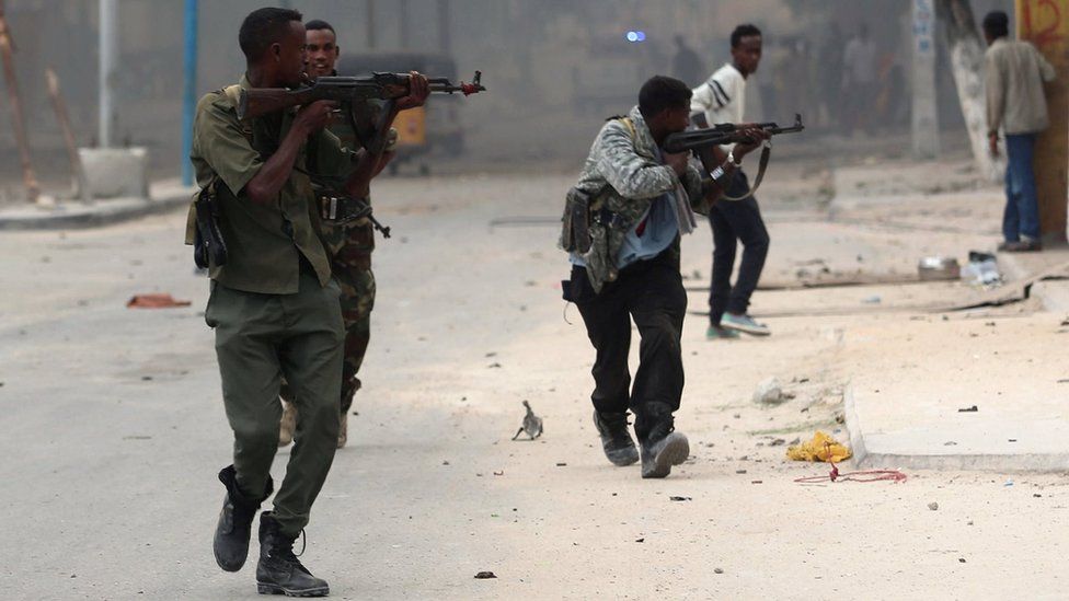 Somali government soldiers take position during gunfire after a suicide bomb attack outside a hotel in Somalia's capital Mogadishu on 25 June