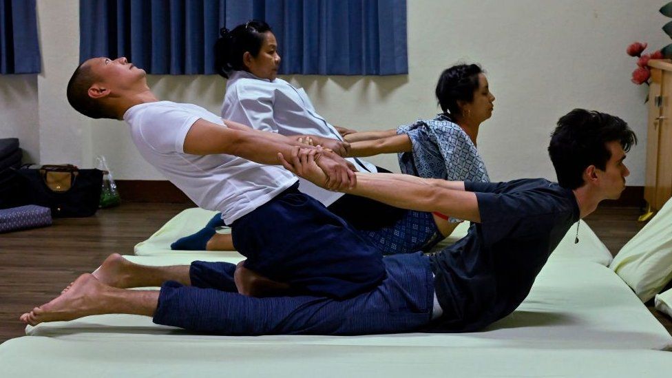 Thai instructor (centre L) trains her students from Chile (centre R), France (front R) and a Thai (front L) at the Wat Po Thai traditional massage school,