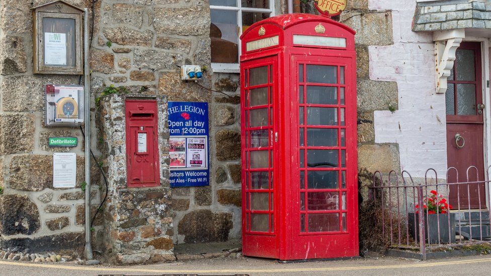 A red telephone box in a Cornish village