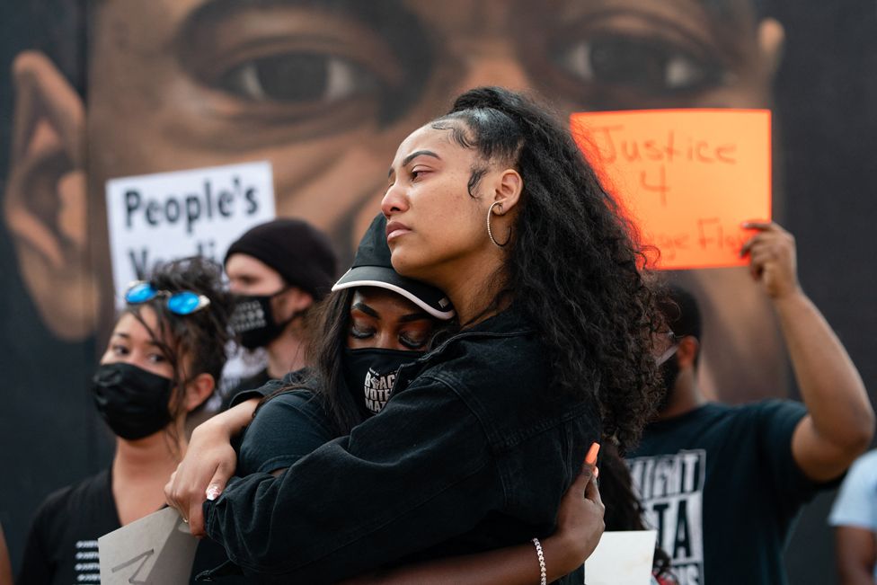 Two women embrace in front of a mural of George Floyd following the guilty verdict the trial of Derek Chauvin on April 20, 2021, in Atlanta, Georgia. - Derek Chauvin, a white former Minneapolis police officer, was convicted on April 20 of murdering African-American George Floyd after a racially charged trial that was seen as a pivotal test of police accountability in the United States