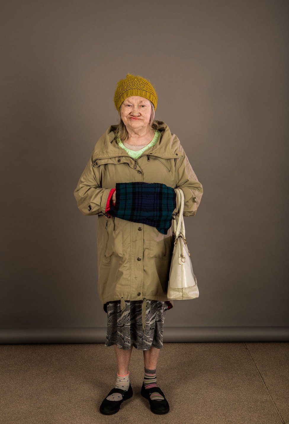 An elderly lady wearing a woolly hat and coat