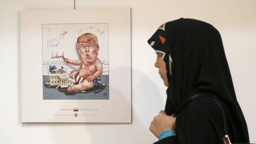 An Iranian woman looks at cartoons of US President Donald Trump at an exhibition of the Islamic Republic's 2017 International Trumpism cartoon and caricature contest, in the capital Tehran on 3 July 2017