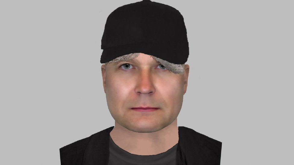 An efit image showing a man wearing a black cap and black top over a dark t shirt