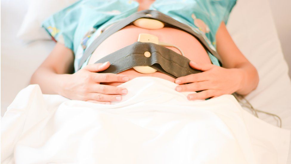 A pregnant woman having her baby's heart rate monitored during labour