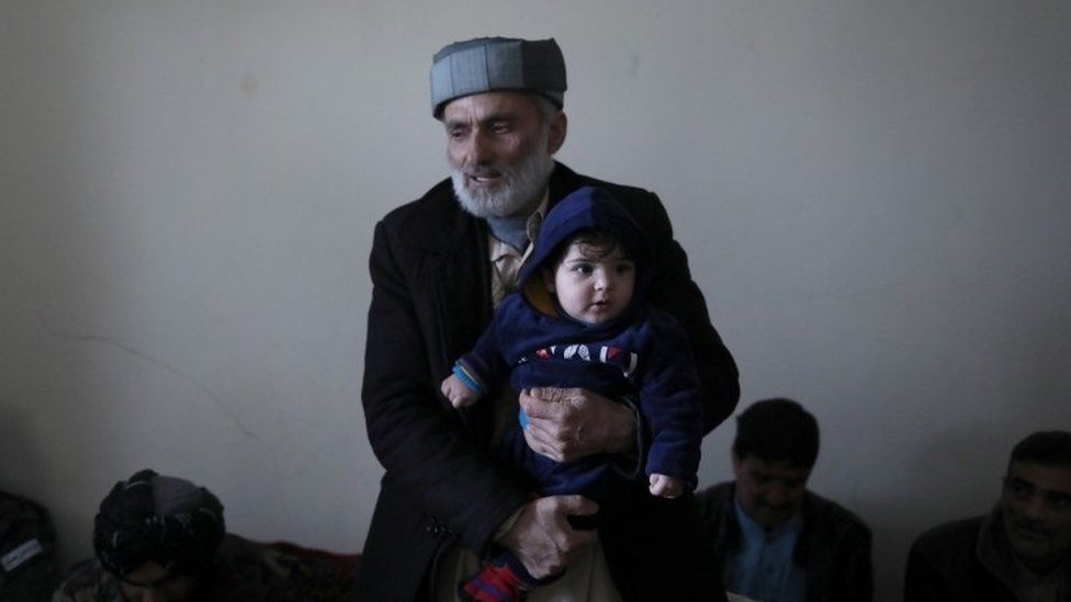 Mohammad Qasem Razawi, grandfather of baby Sohail Ahmadi, holds his grandson