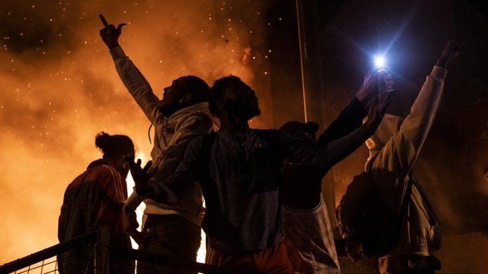 Protesters cheer as the Third Police Precinct burns behind them on 28 May 2020 in Minneapolis, Minnesota.