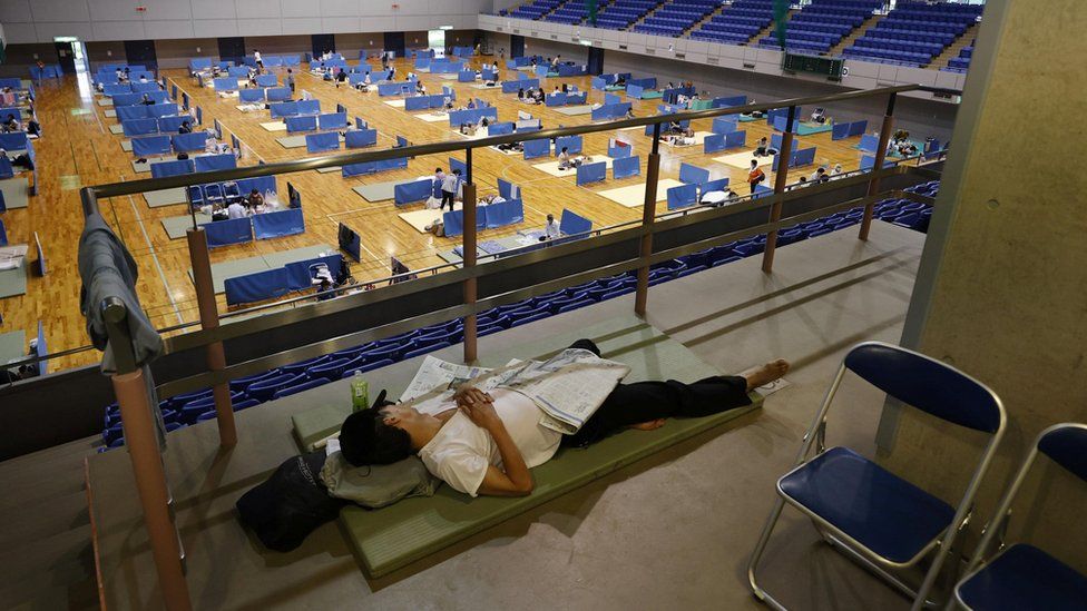 A man lies on a mattress at a shelter for evacuees of torrential rain in Hitoyoshi, Kumamoto prefecture, southern Japan,