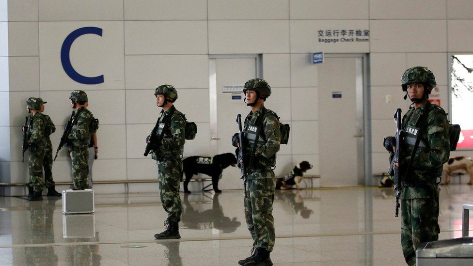 Paramilitary policemen stand guard near the site of a blast at a terminal in Shanghai's Pudong International Airport 12 June 2016