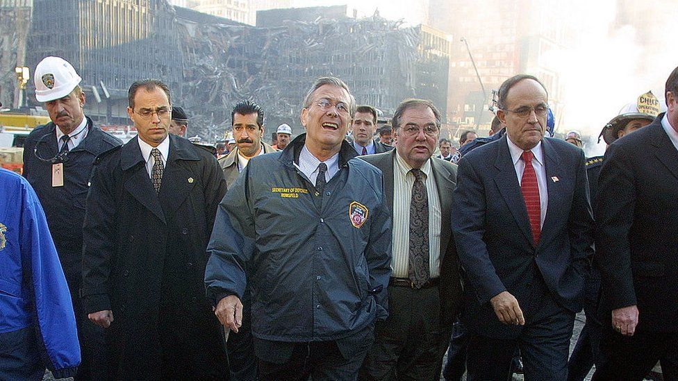 Министр обороны США Дональд Рамсфелд (в центре) осматривает территорию Всемирного торгового центра с мэром Нью-Йорка Руди Джулиани (3-й справа) в Нью-Йорке 14 ноября 2001 г. | ||