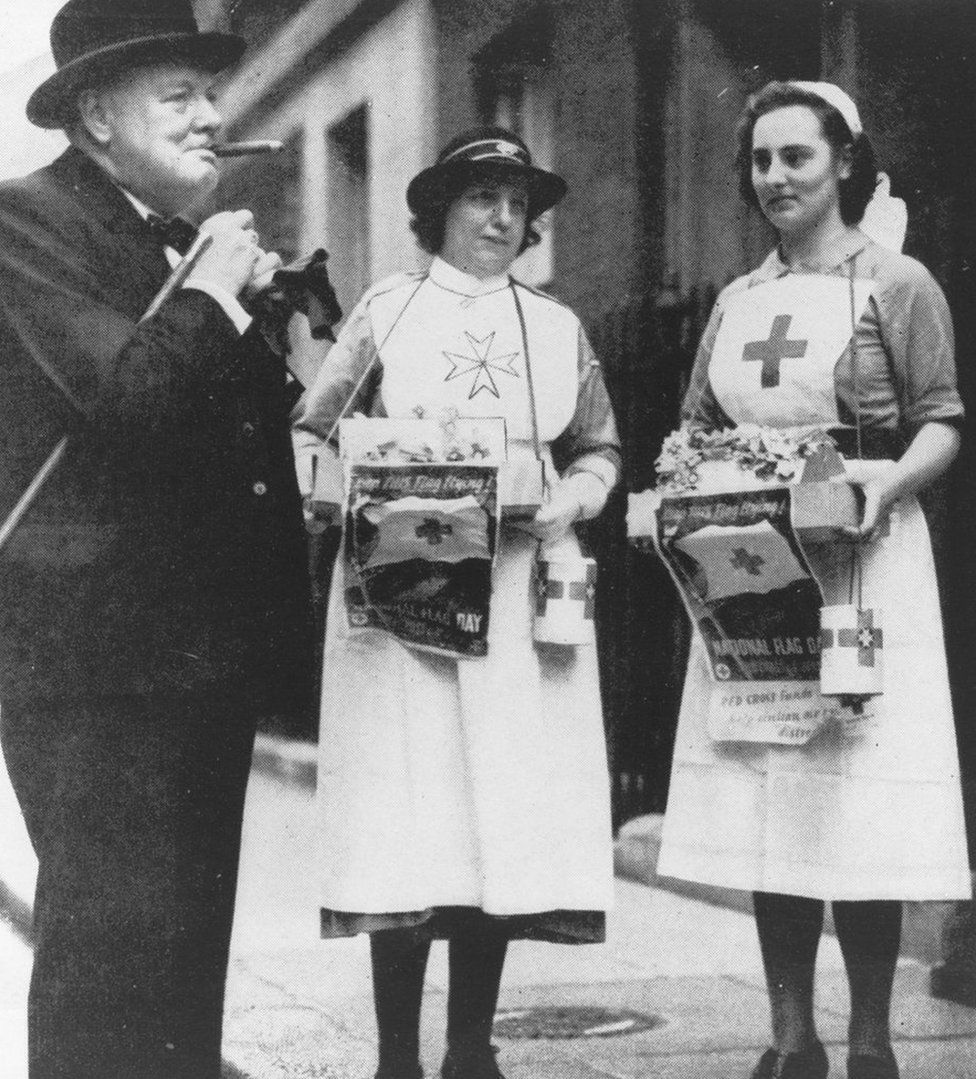 Sir Winston Churchill stands with two nurses