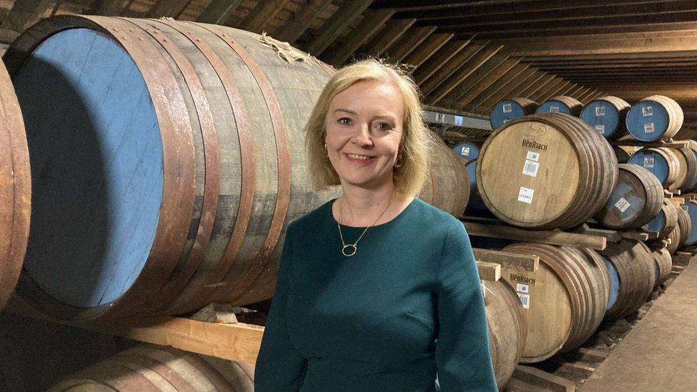 Liz Truss with whisky barrels in the background