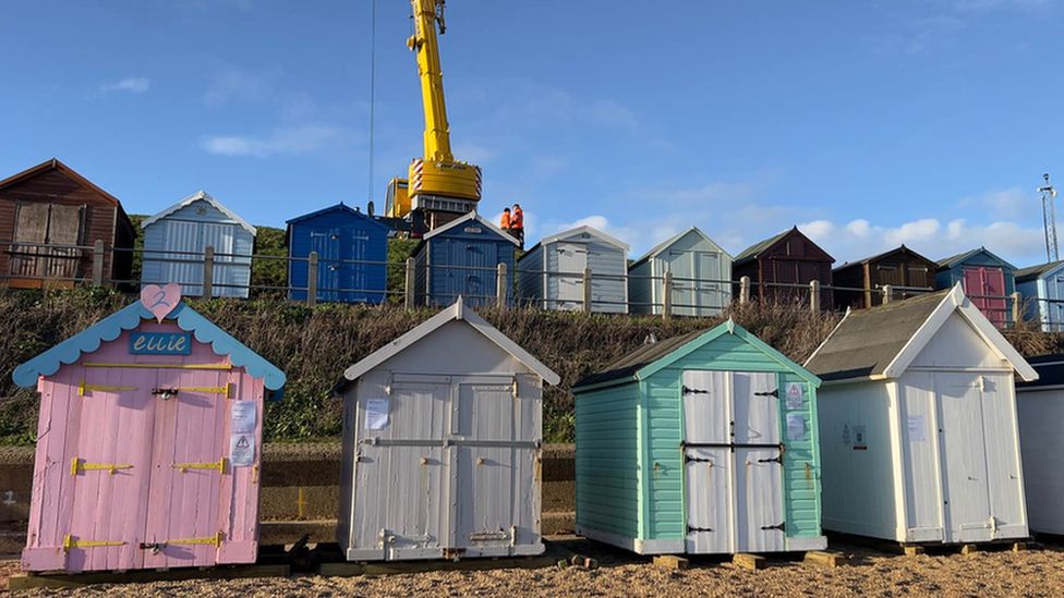A crane lifting up one of the beach huts at Felixstowe beach