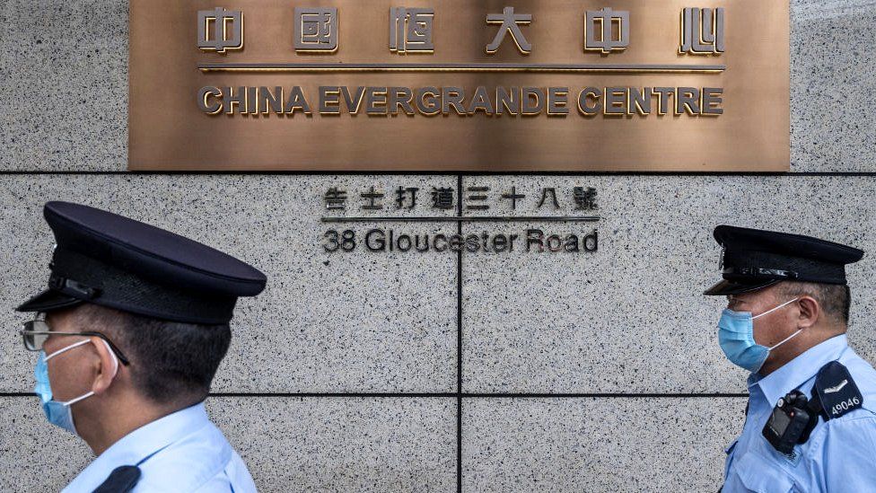 Police officers walk past the China Evergrande Centre in Hong Kong.