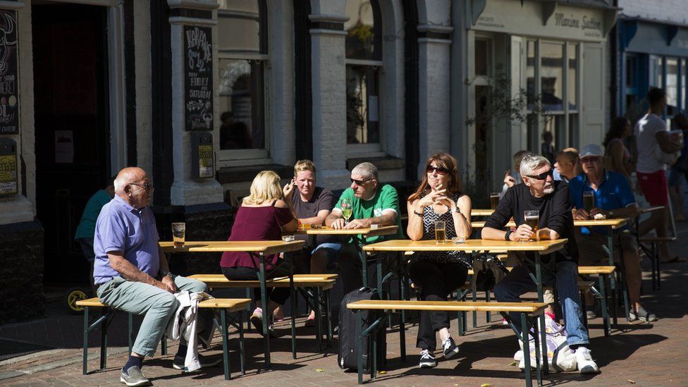 People sit outside a pub in the sunshine in Margate