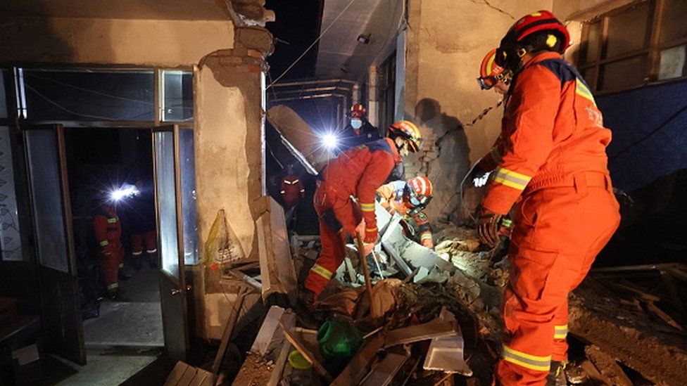 Rescue workers search a house for survivors in in Kangdiao village, Dahejia, Jishishan