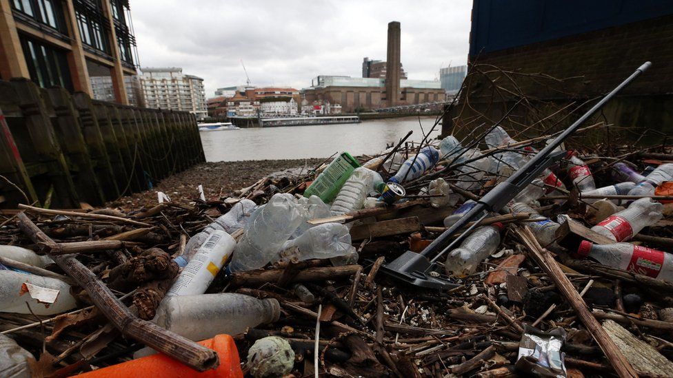 Plastic bottles and other waste littering the foreshore of the River Thames at Queenhithe Dock in London.