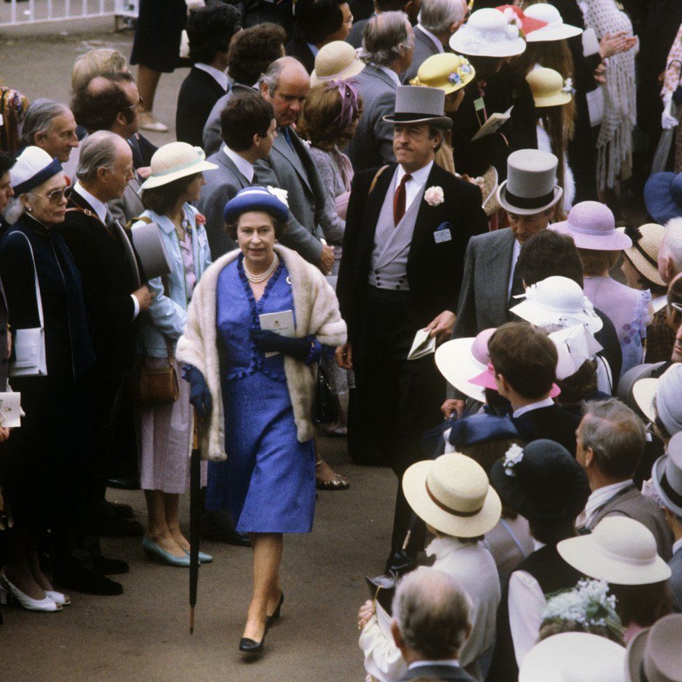 Queen Elizabeth II walking through the crowds at the Royal Ascot race meeting.