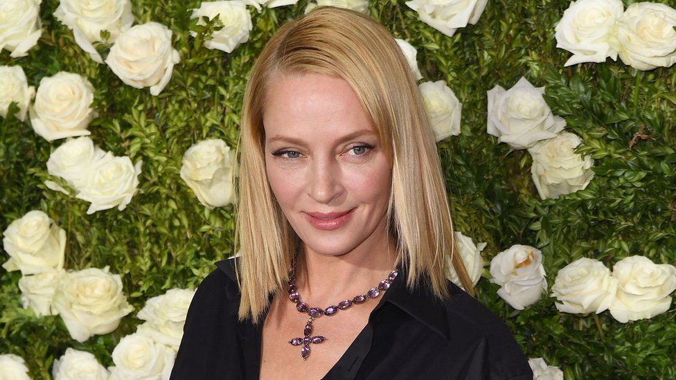Uma Thurman in June 2017, photographed in front of a wall of white roses