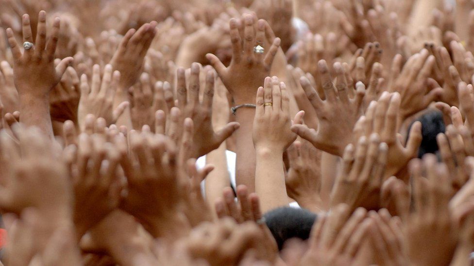 Руки подняты, когда тысячи католических паломников толкаются в рамках ежегодной традиции на Филиппинах
