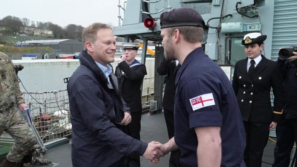 Grant Shapps shakes hands with a Royal Navy representative