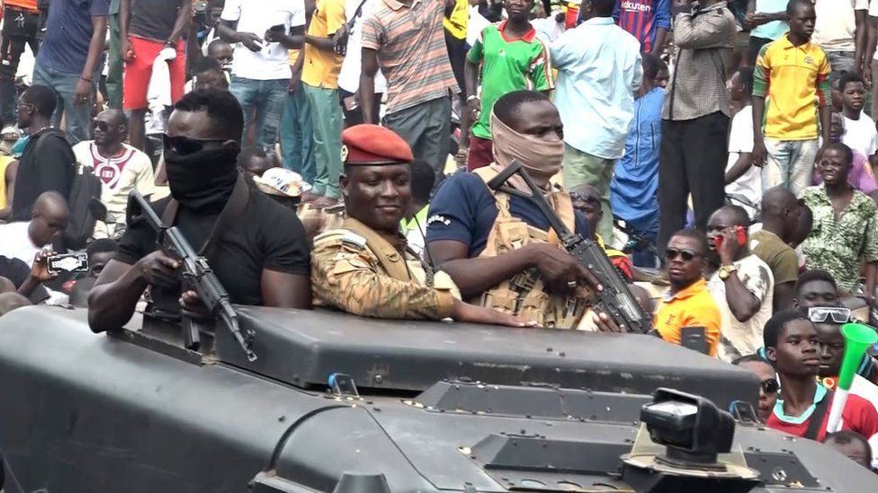 В этом видеофрагменте, взятом из кадра AFPTV, новый самопровозглашенный лидер военной хунты, правящей в Буркина-Фасо, капитан Ибрагим Траоре (в центре), проходит парадом по улицам Уагадугу и приветствует ликующую толпу 2 октября 2022 года. Буркина-Фасо новый самопровозглашенный лидер путча призвал к прекращению насилия против французских объектов после серии нападений на здания, связанные с бывшей колониальной державой