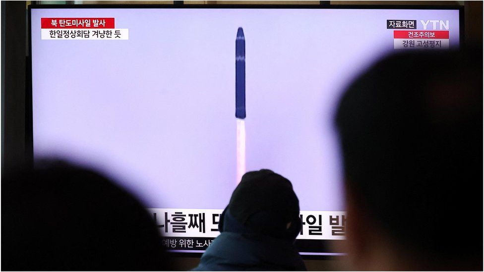 People watching a news report on the missile