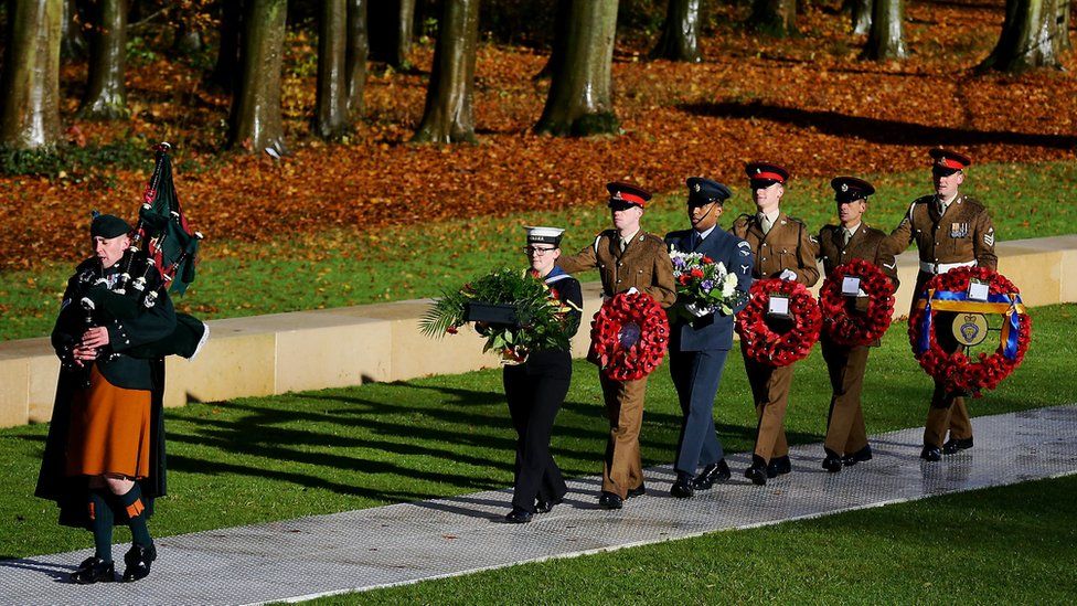 A lone piper led a military escort of the wreaths to the nearby memorial
