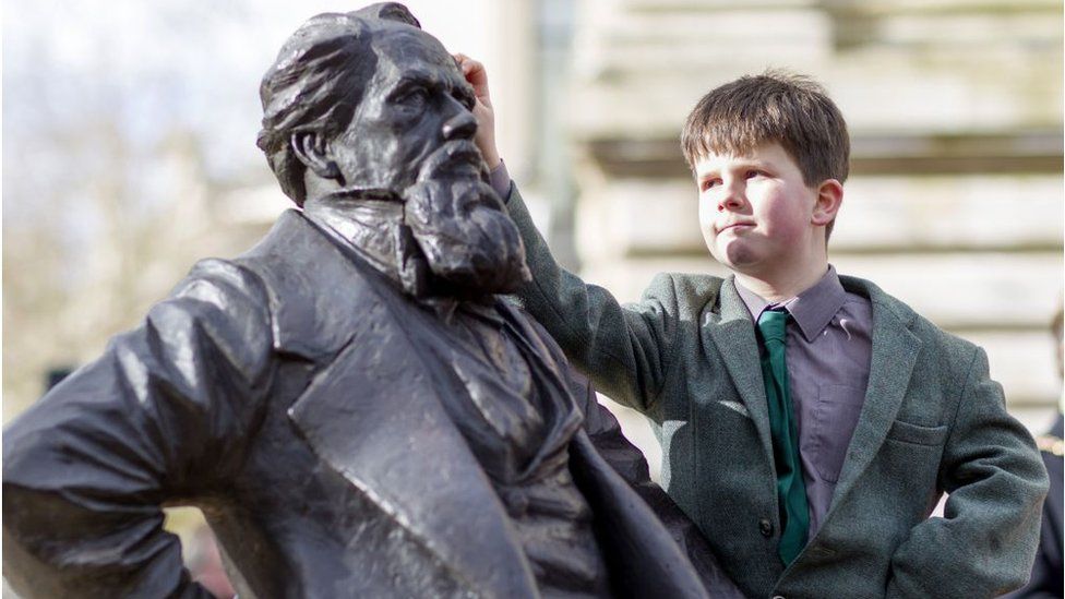 Statue of Charles Dickens in Guildhall Square, Portsmouth, with his great, great, great grandson Oliver Dickens, 9, in 2014