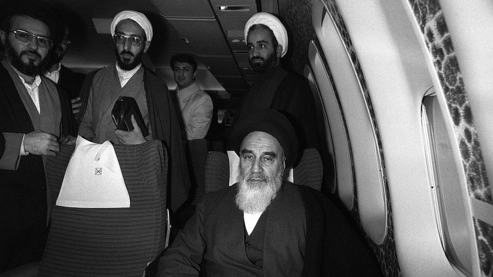 Revolutionary leader Ayatollah Ruhollah Khomeini (C) posing aboard the Air France Boeing 747 jumbo that flew him back from exile in France to Tehran on 1 February 1979