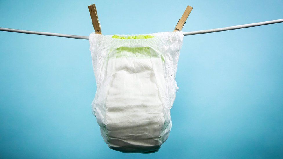 A stock photo shows an unused disposable nappy pinned on a washing line