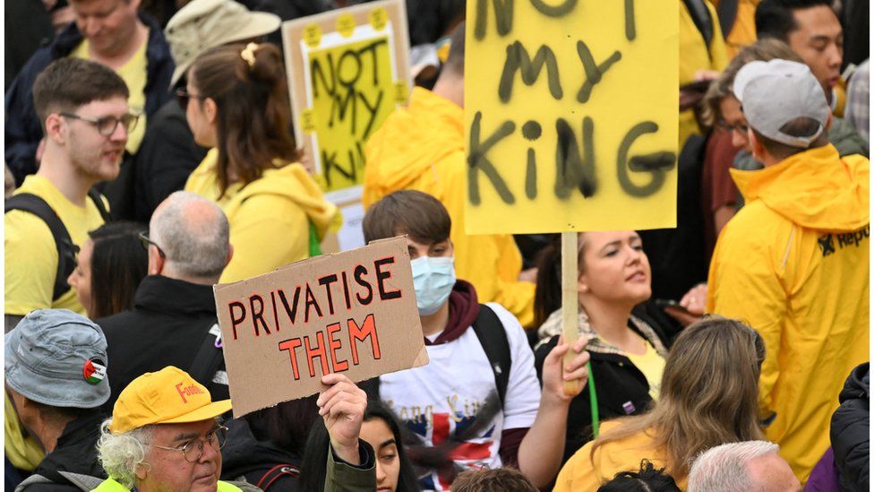 Protesters dressed in yellow hold up placards saying "not my king" in Trafalgar Square on 6 May