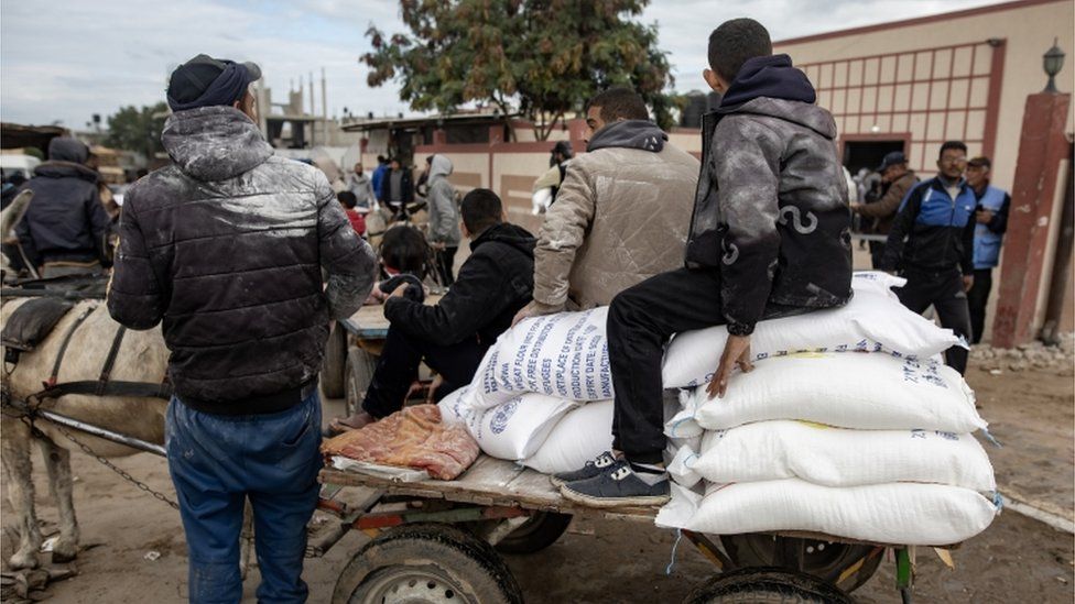 Palestinians receive flour bags distributed by UNRWA in Rafah, southern Gaza Strip, 28 January 2024
